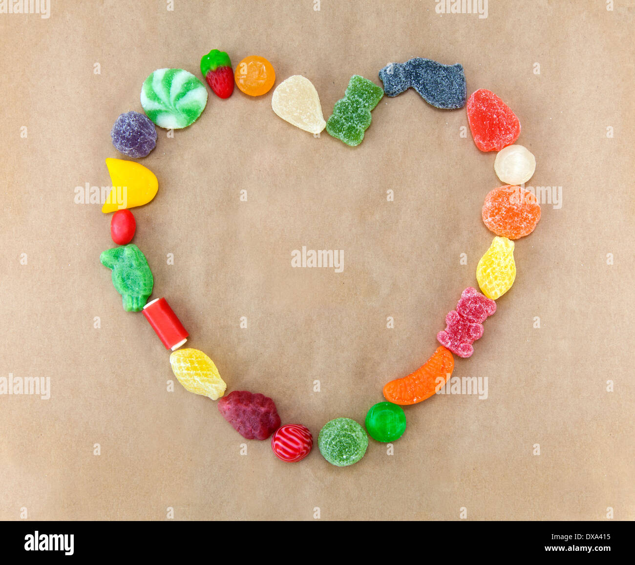 Forma di cuore fatta di caramelle diverse su un sacchetto di carta. Foto Stock