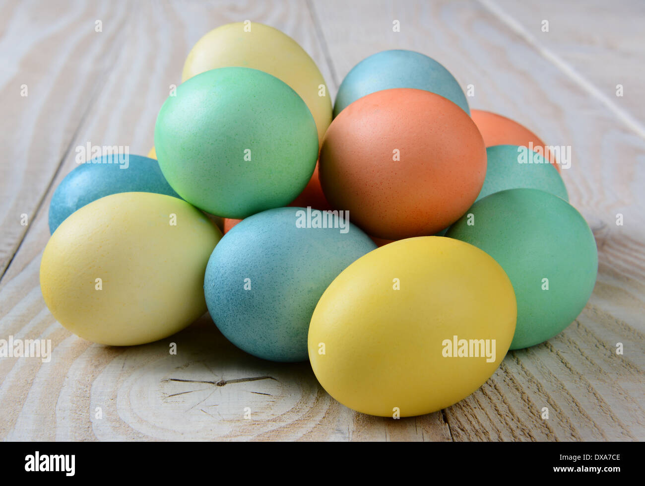 Primo piano di una pila di pastello di uova di Pasqua in un casale rustico stile tabella. Formato orizzontale. Foto Stock