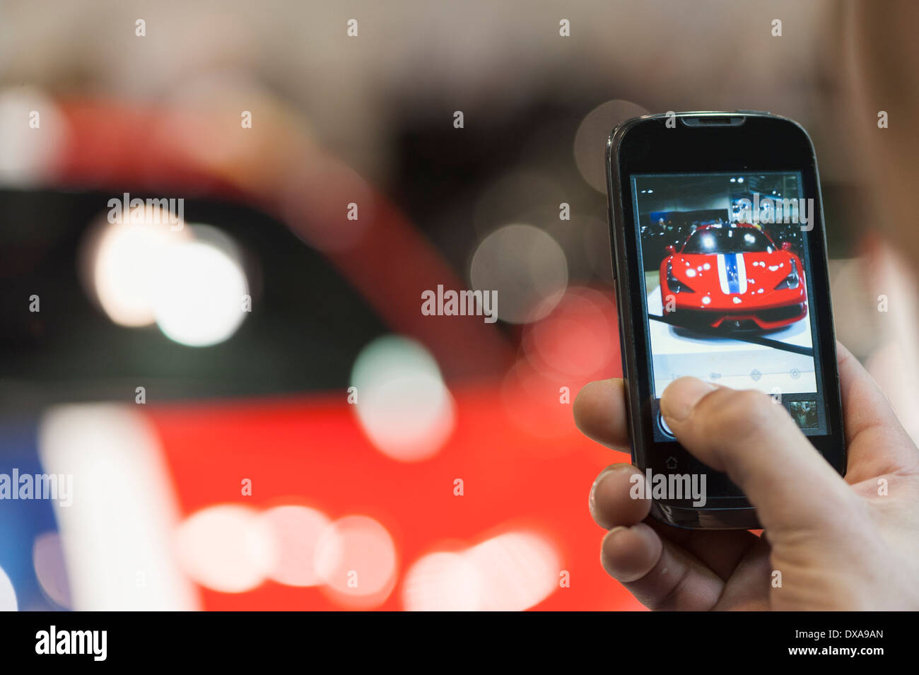 Un visitatore della Zurich Motor Show di Zurigo è scattare una foto di una Ferrari F458 Speciale di vettura sportiva di lusso con il suo iPhone Foto Stock
