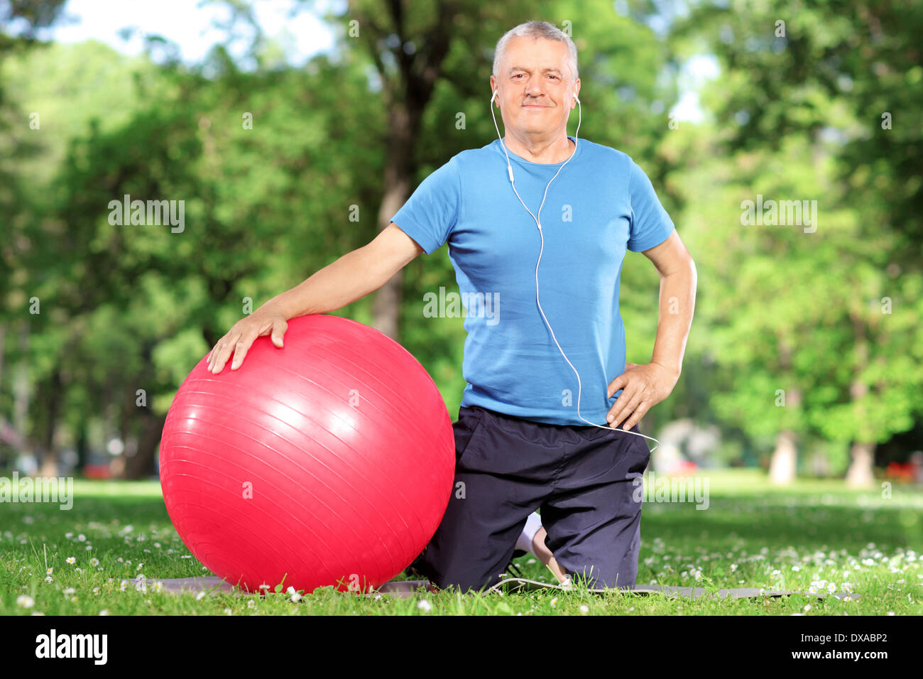 Uomo maturo con una palla ginnica in un parco Foto Stock