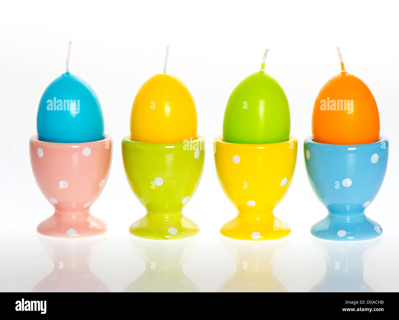 Multicolori uova di pasqua candele in eggcups Foto Stock