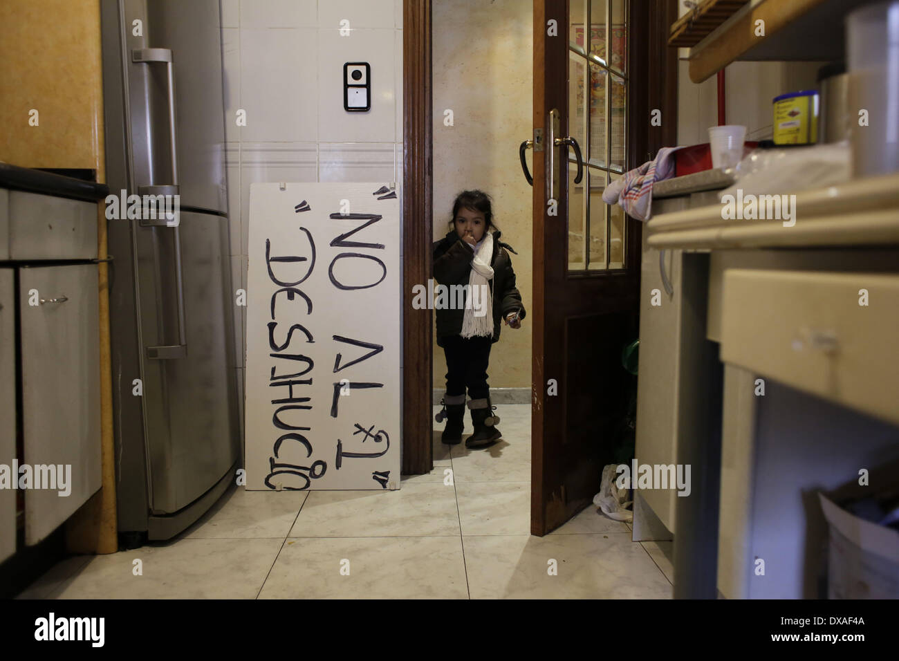 Madrid, Spagna. Xxi Mar, 2014. Dayana Chasi Saavedra, 3 anni, gesti vicino ad una lettura della targhetta ''No sfratto'' come la sua famiglia attendere la commissione giudiziaria e delle forze di polizia di arrivare per loro lo sfratto, in Spagna a Madrid, venerdì 21 marzo, 2014. Dayana vive con sua sorella, i suoi genitori ed i due zii e nonni. Il Chasi Sanguna famiglia, originariamente da Ecuador, acquistato un euro 259.000 (US$ 357,453) appartamento da prendere un mutuo con banca Bankia in 2004, ma hanno cessato di effettuare dei pagamenti dopo la Dayana zii perso i loro posti di lavoro nel settore della costruzione nel 2010 e suo padre l Foto Stock