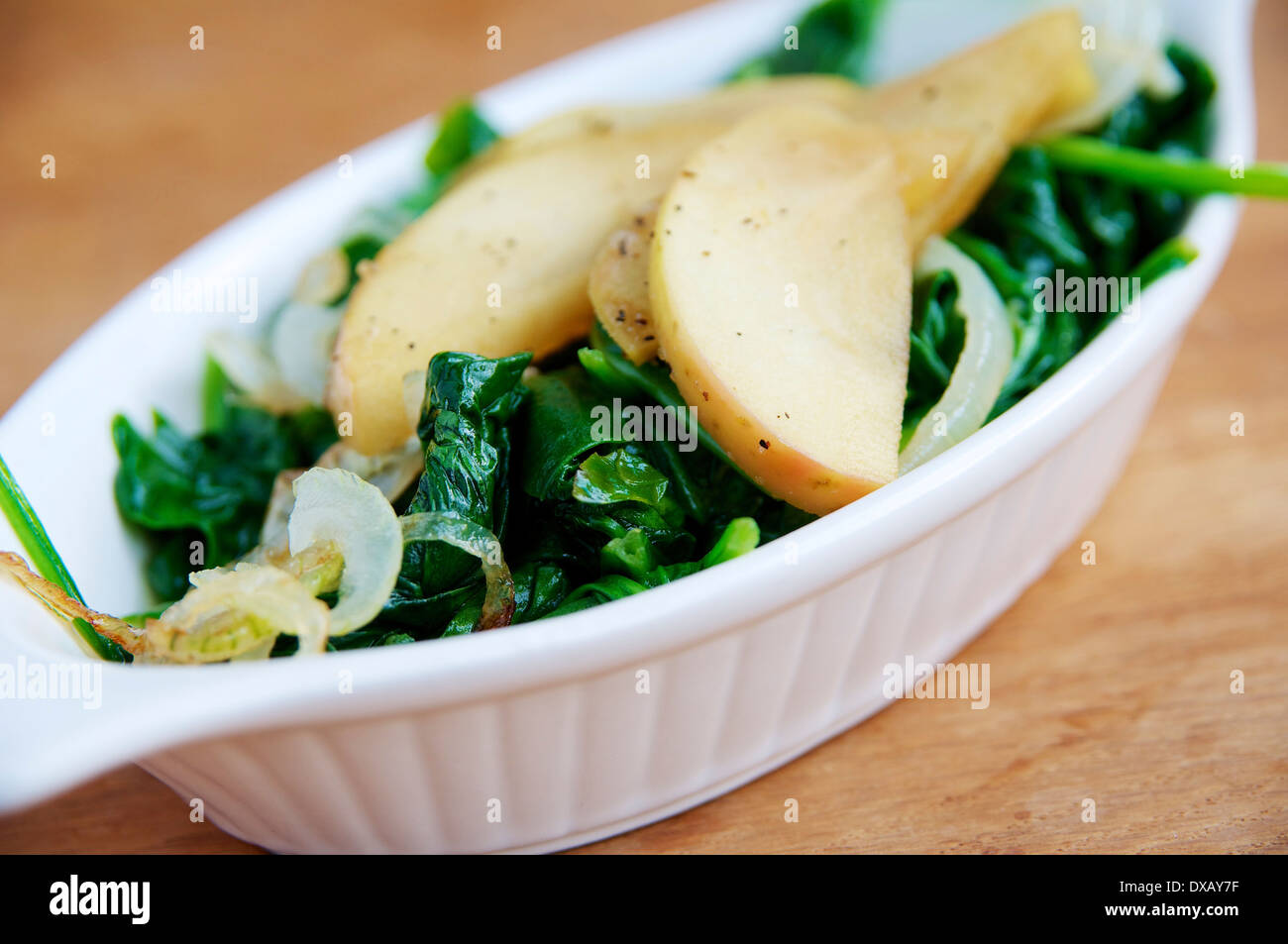 Saltata di spinaci con mele e cipolle. Foto Stock