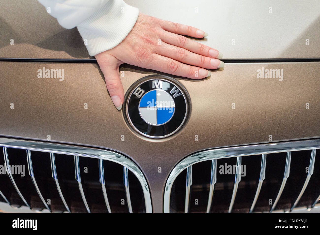 Mano femmina e logotipo BMW sul nuovo modello di auto di prestigio. Foto Stock