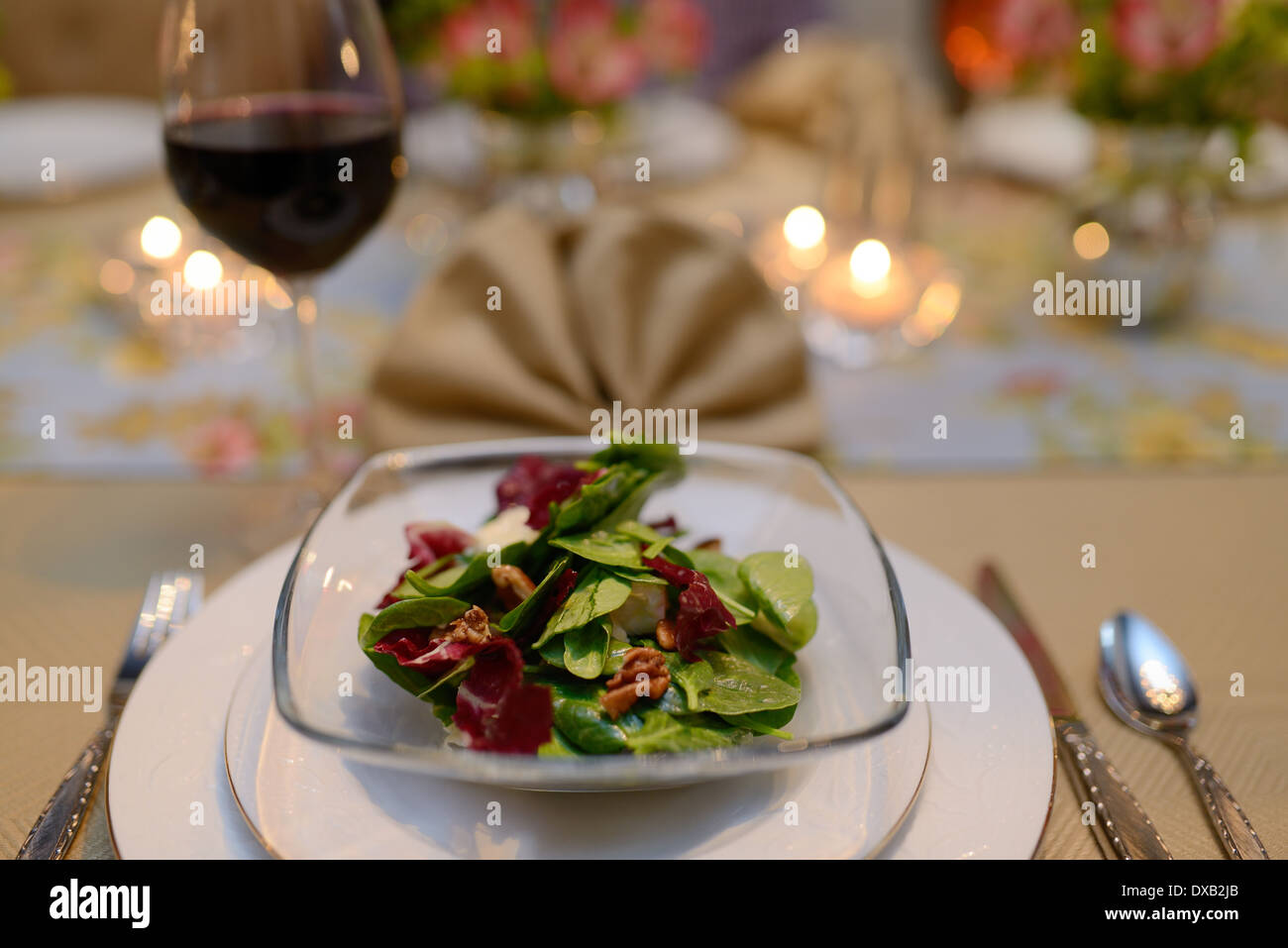 Primo corso insalata in home sala da pranzo tavolo per una cena con il tovagliolo e vino rosso Foto Stock