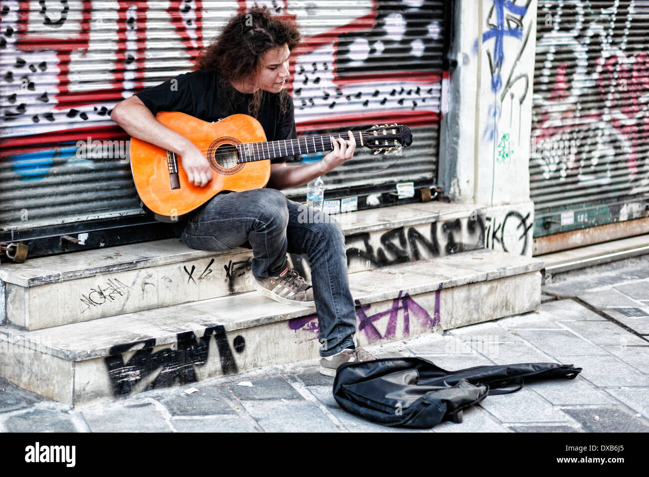 Un musicista suonando la chitarra in strada di Atene, Grecia Foto Stock