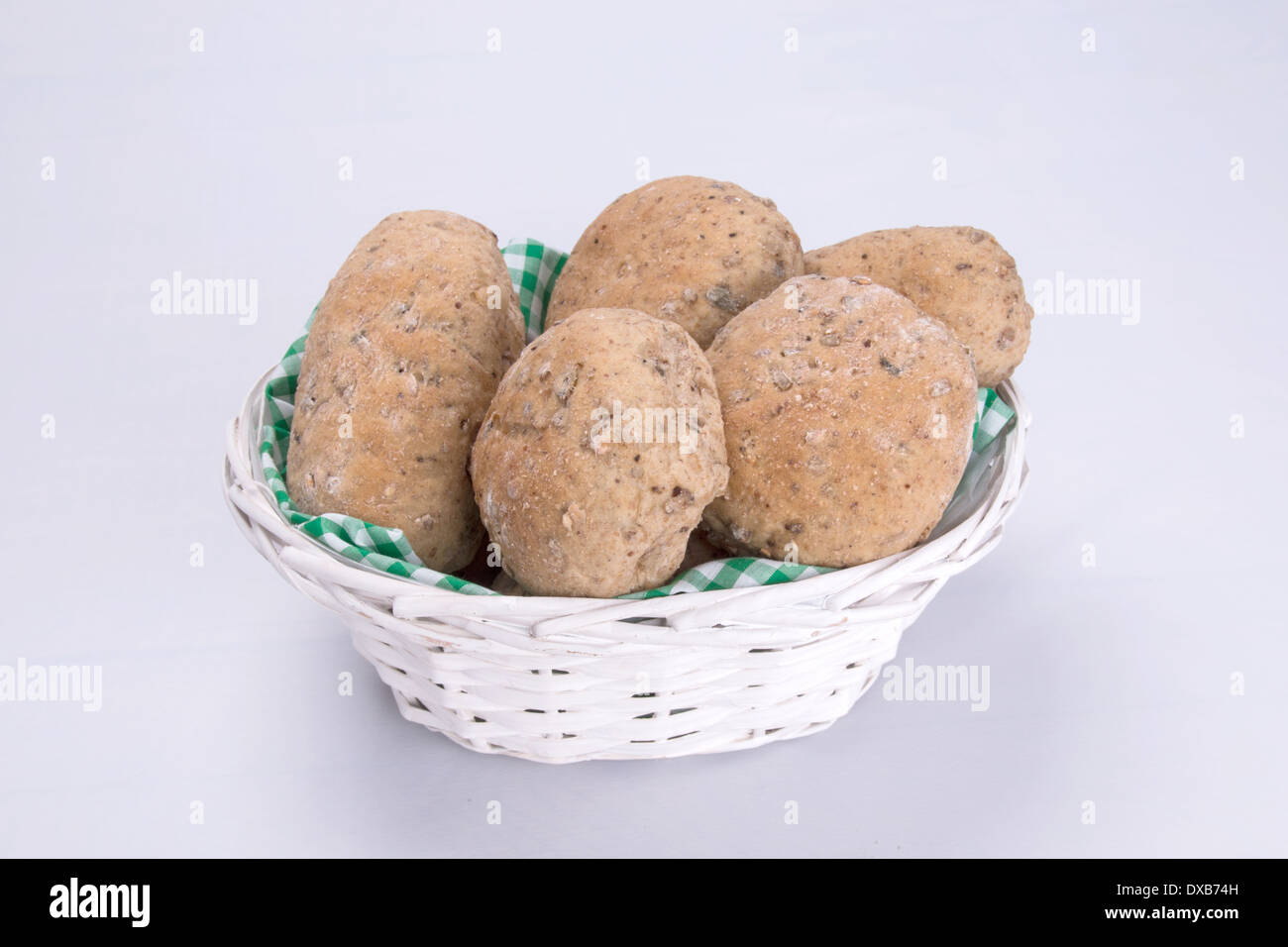 Il granaio di marrone/seminate integrale ciambelle di pane/torte/baps in un cestino foderato con una verde e bianco a scacchi igienico (13 di 15) Foto Stock