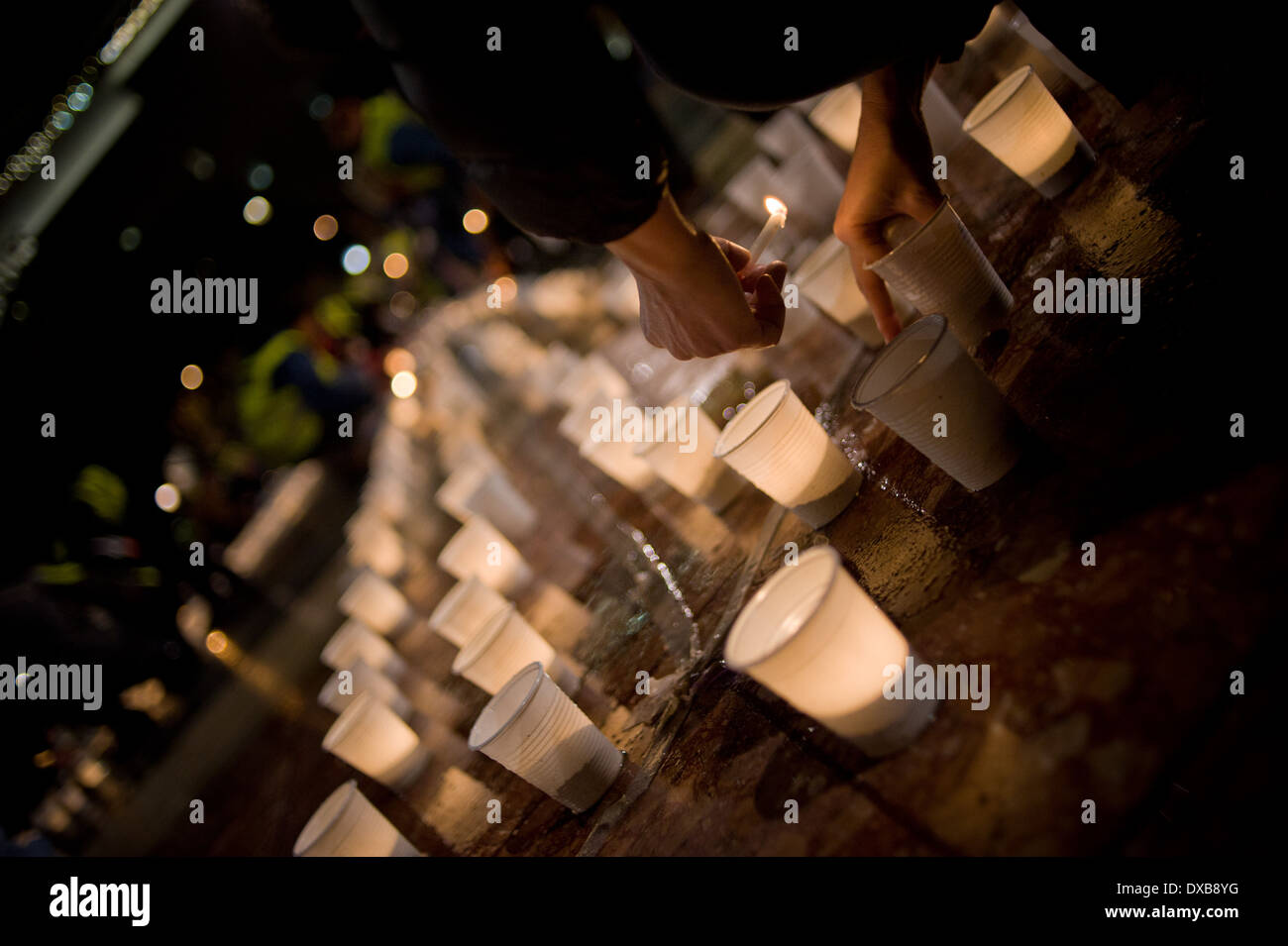 Persone accendendo candele in strada Foto Stock