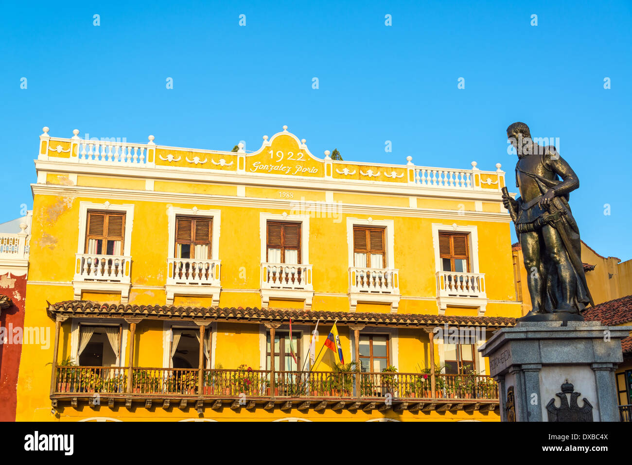 Giallo edificio coloniale a Cartagena, Colombia con una statua di Pedro de Heredia, il fondatore della città Foto Stock