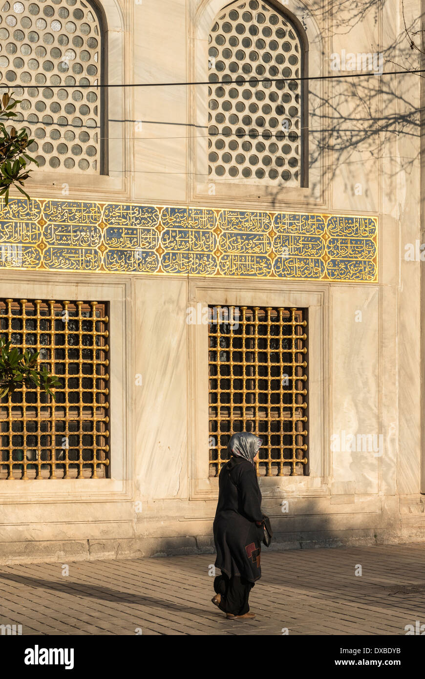 Tradizionalmente un vestito donna turca che passa i mausolei imperiali a Aya Sofya, Sultanahmet, Istanbul, Turchia. Foto Stock