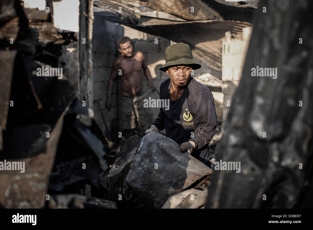 Caloocan, Filippine. 23 Mar, 2014. I residenti di raccogliere rottami di metallo da bruciato shanties dopo un incendio senza visceri una zona residenziale in Caloocan city, a nord di Manila, Filippine, 23 marzo 2014. Almeno 1700 famiglie sono rimaste senza tetto dopo 3 distinti incendi eviscerato 700 case in un arco di 24 ore. Gli incendi hanno avuto luogo come il paese osserva la prevenzione degli incendi mese.Foto: Ezra Acayan/NurPhoto Credito: Ezra Acayan/NurPhoto/ZUMAPRESS.com/Alamy Live News Foto Stock