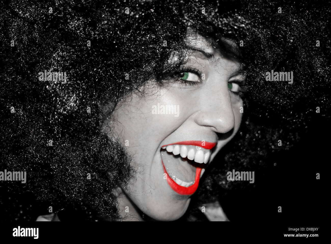 Attraente giovane donna vestita di nero parrucca e ridere direttamente nella fotocamera. Foto Stock