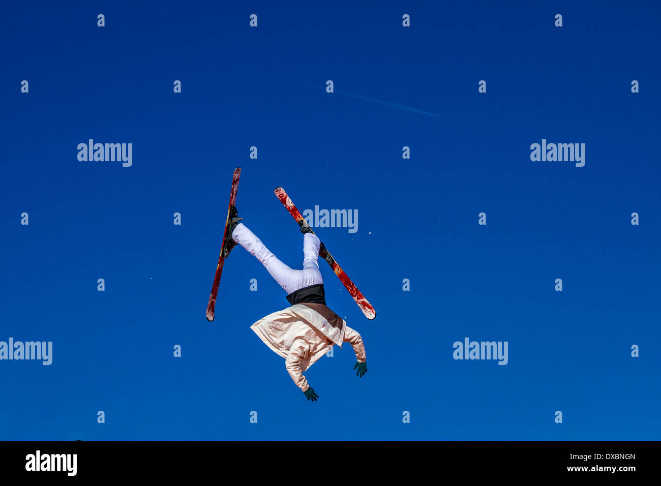 Sciatore a testa in giù e fuori controllo contro un cielo blu Foto Stock