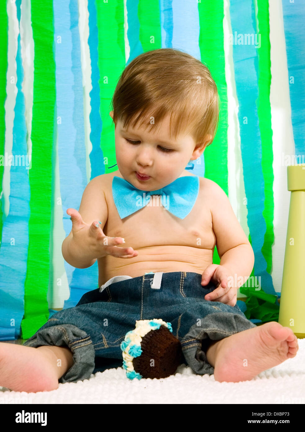 Bambino con blue bow tie-festeggia il suo primo compleanno e mangia la torta Foto Stock