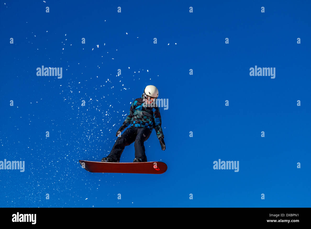 Snowboarder che viaggiano attraverso l'aria Foto Stock