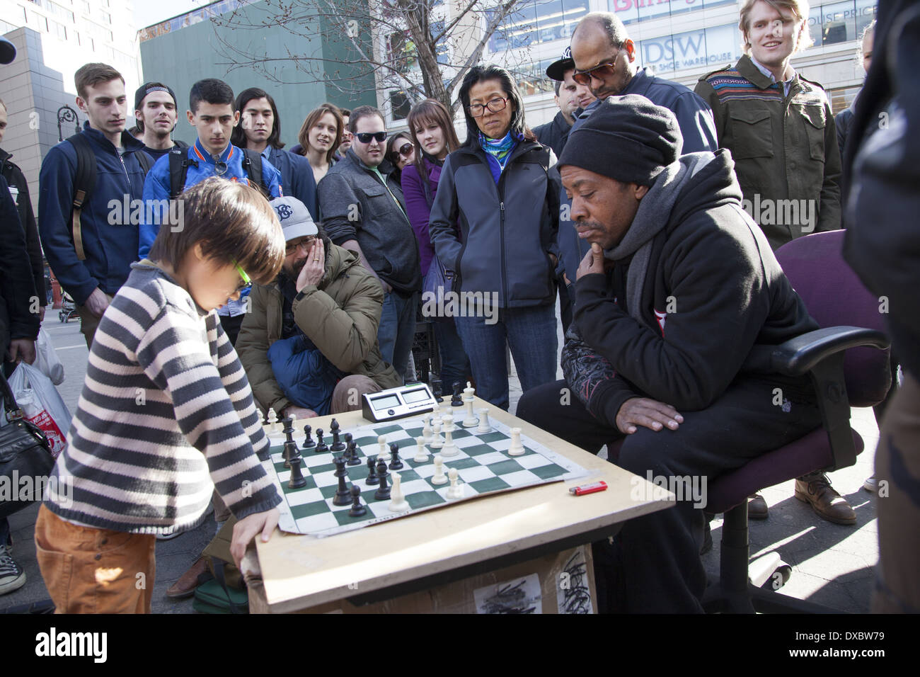 Giovane prodigio giocatore di scacchi assume i grandi ragazzi di Union Square Park, New York. Foto Stock