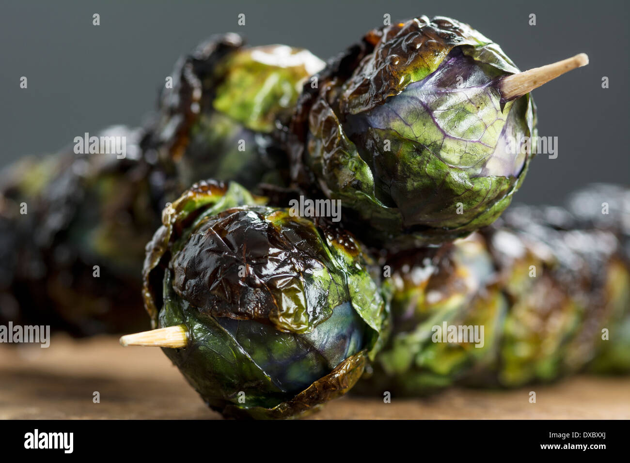 Tre grigliate viola organico beccucci di Bruxelles su spiedini impostato su legno Foto Stock