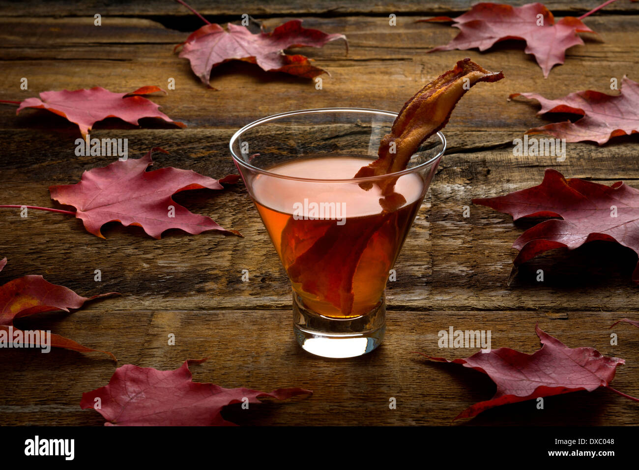 Maple whiskey bacon cocktail sul legno ruvido ed aceri e foglie Foto Stock