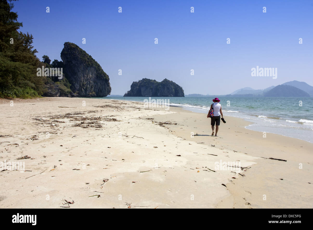 Donna che cammina da sola lungo Yao beach nella provincia di Trang, Thailandia Foto Stock