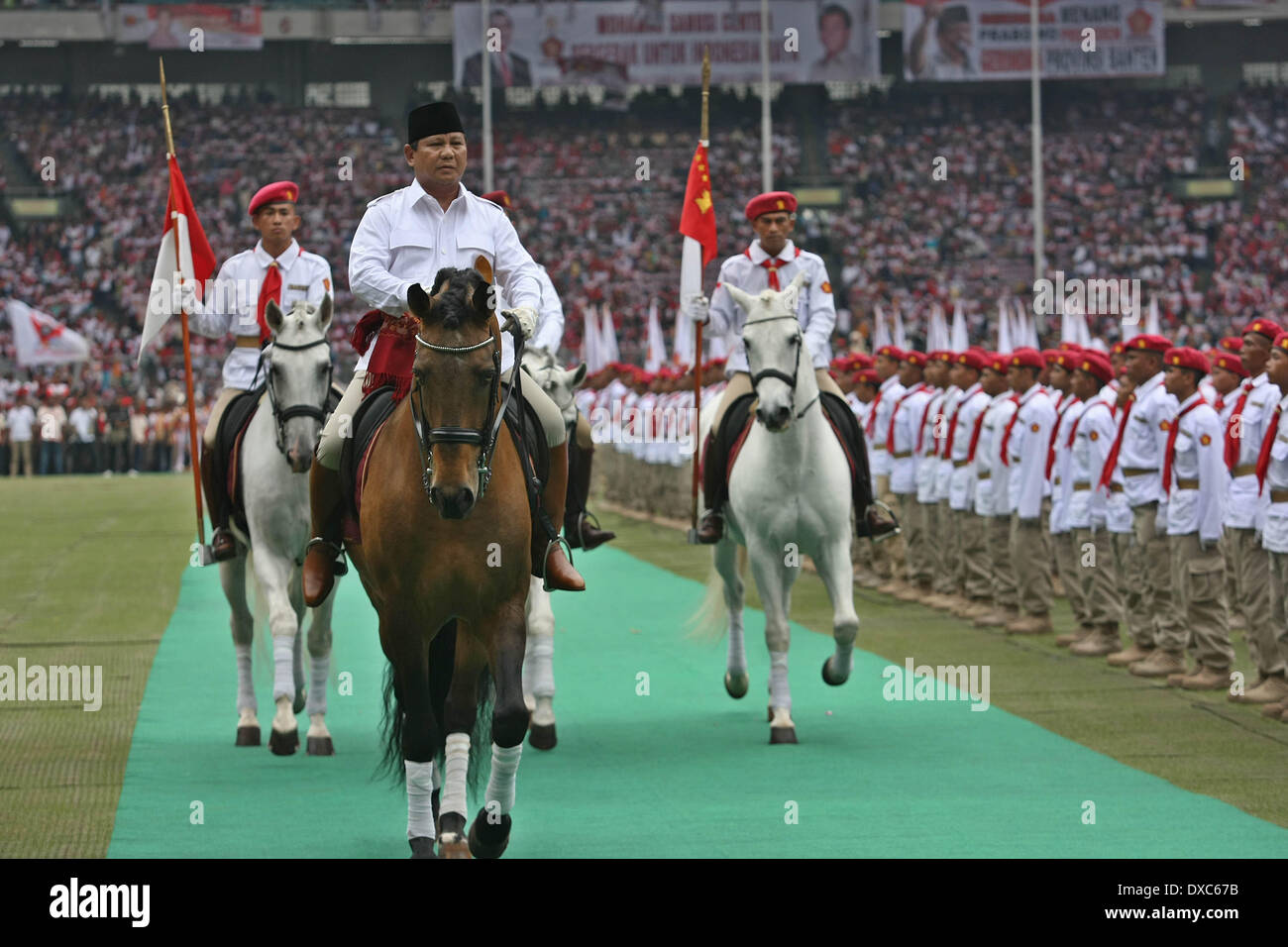 Centro di Jakarta, Jakarta, Indonesia. 23 Mar, 2014. PRABOWO SUBIANTO (al centro), il candidato presidenziale per il grande movimento di Indonesia o Gerindra, sfilate a cavallo come egli ispeziona un appello dei sostenitori come frequenta una campagna raccolta nella prospettiva delle elezioni legislative in Gelora Bung Karmo Staduim. PRABOWO SUBIANTO, ex comandante di Indonesia di forze speciali o Kopassus, è il principale rivale per il popolare governatore di Jakarta, Joko Widodo, chi è in esecuzione anche per il presidente del paese le elezioni presidenziali del 9 luglio che seguirà un voto legislativo il 9 aprile. (Cre Foto Stock