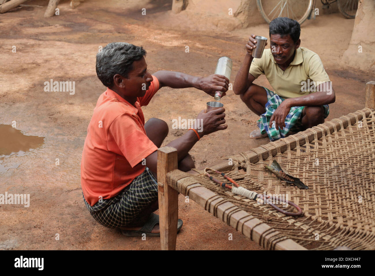 Uomini tribali Khadia potabile (riso birra). Tribù Santhal. Villaggio Jarweadhi, blocco Bishangarh, Distretto Hazaribaug, nello stato del Jharkhand Foto Stock