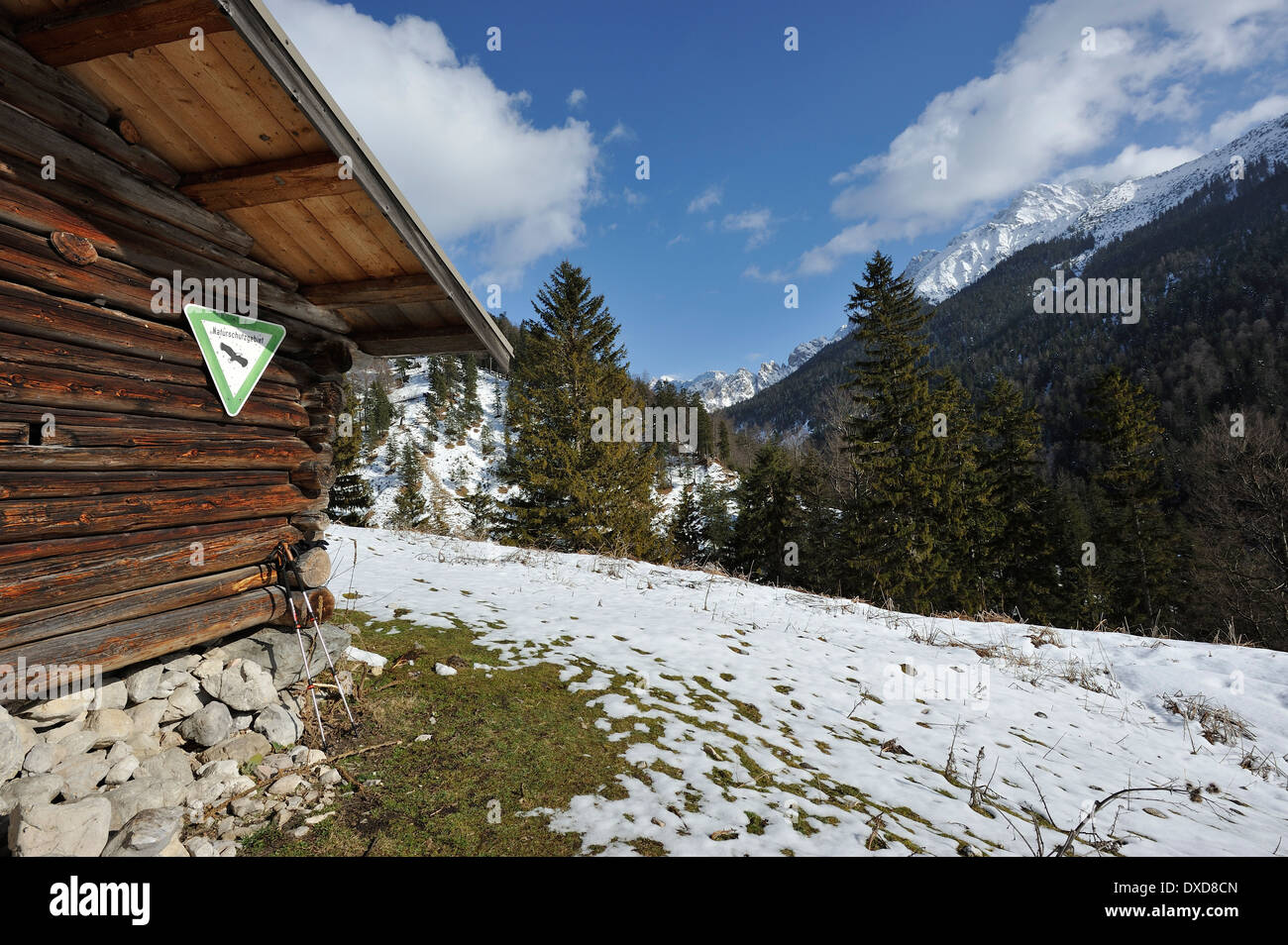 Rifugio di montagna con riserva naturale segno e pali trekking, Ochsenalm in presenza di neve sul Karwendel mountain range, Baviera, Germania Foto Stock