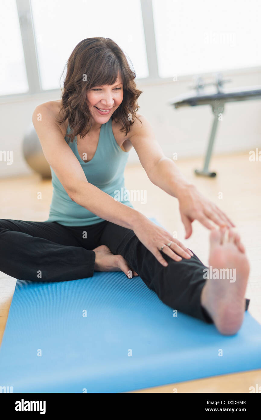 Donna stretching in palestra Foto Stock