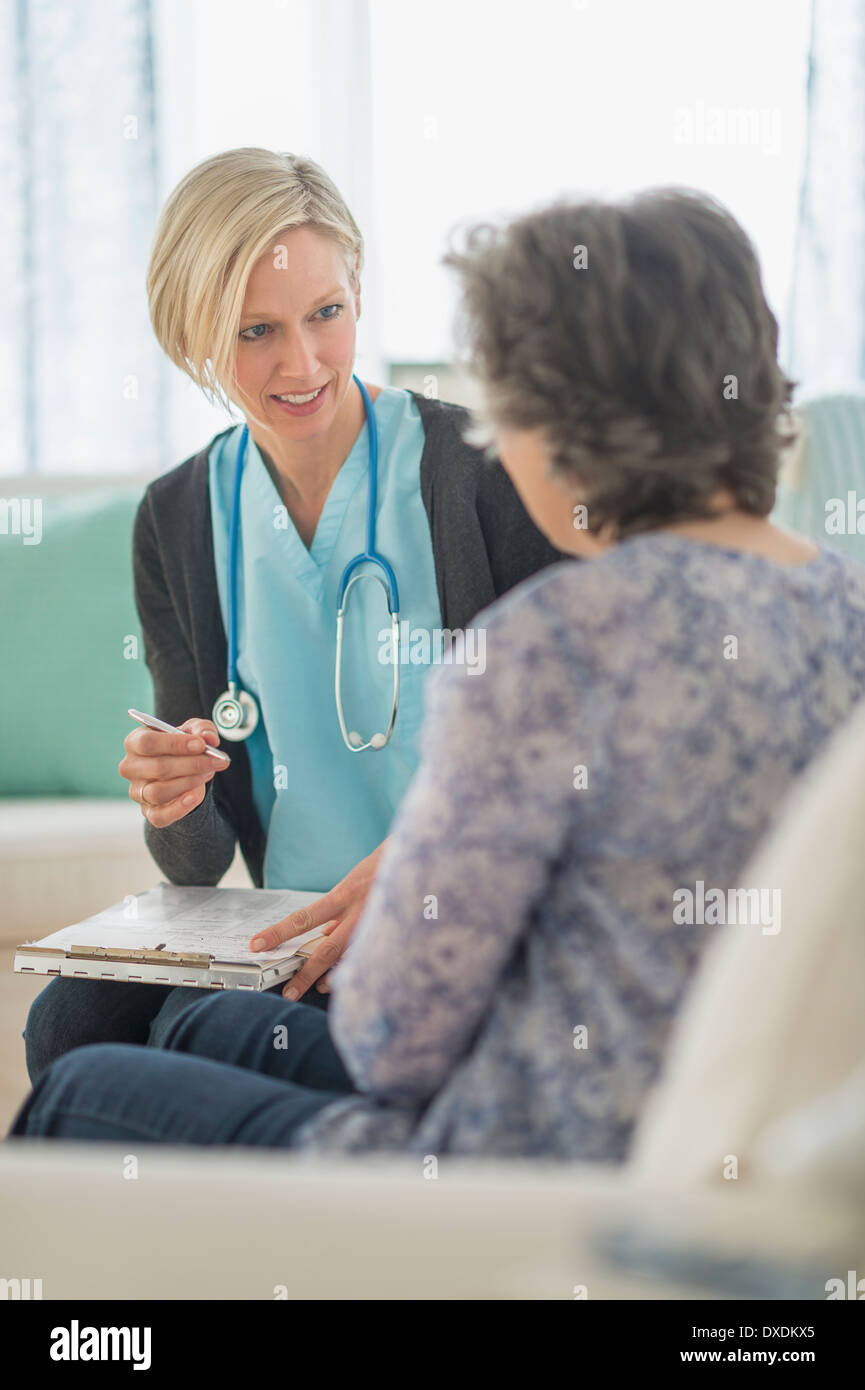 Infermiera e donna matura seduti sul divano Foto Stock