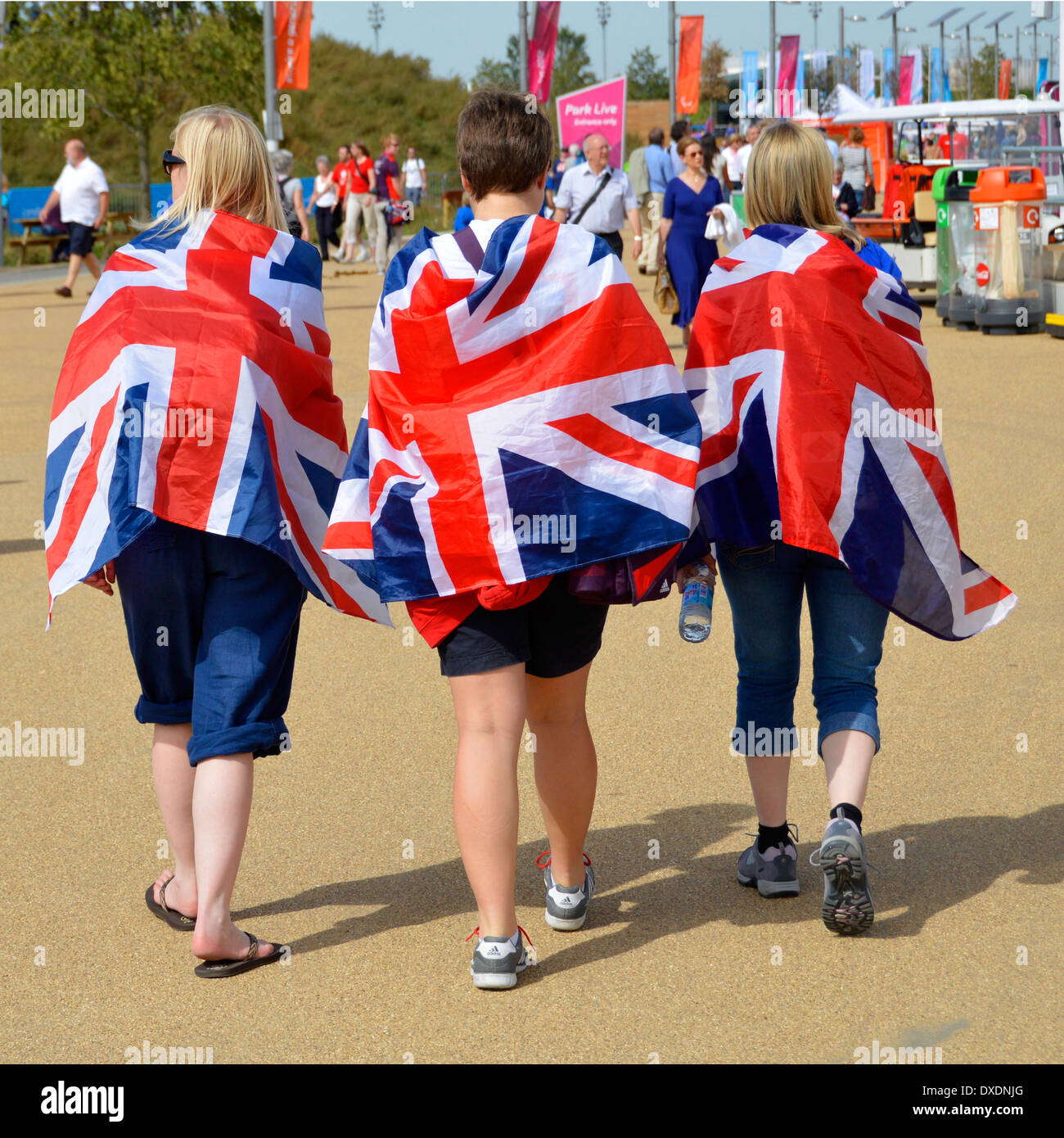 Londra 2012 Giochi Paralimpici indietro Guarda tre spettatori che camminano verso luoghi di ritrovo nella soleggiata giornata estiva a Olympic Park Stratford Newham East London Inghilterra Regno Unito Foto Stock