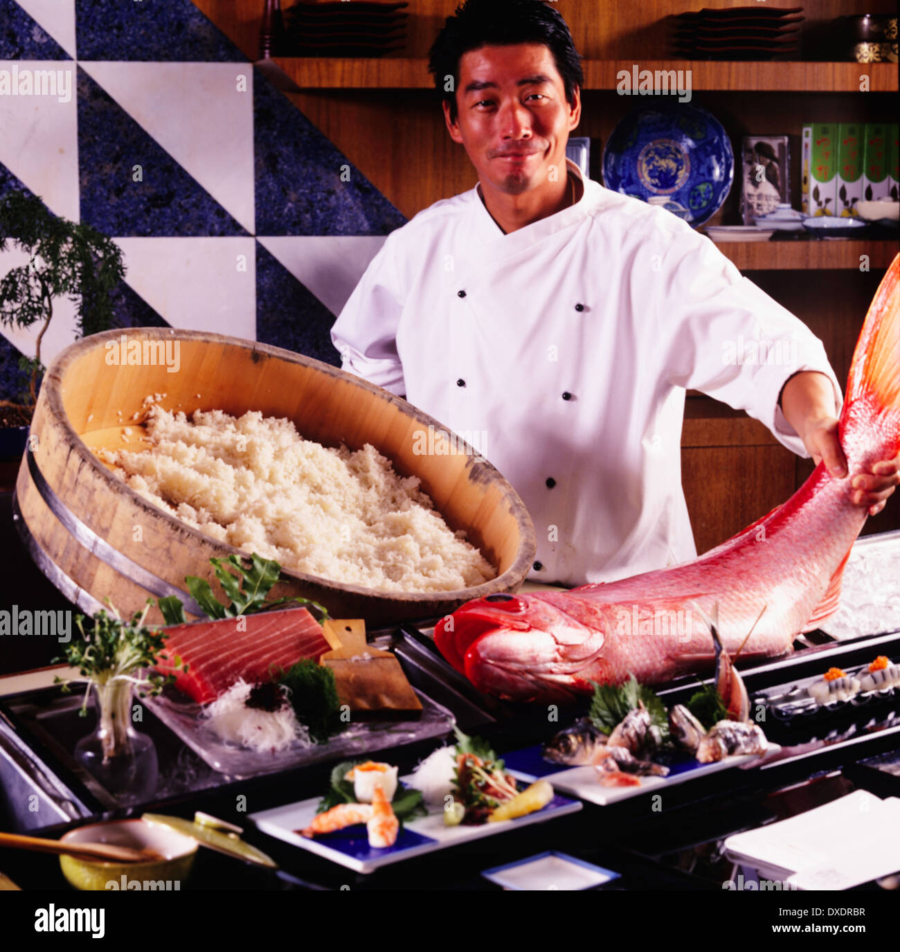 Cucina asiatica, sushi chef e Red Snapper pesce, Onaga, nigiri sushi, tonno crudo in primo piano Foto Stock
