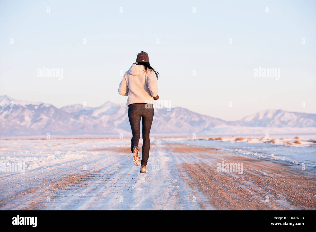 Vista posteriore della donna in esecuzione nel paesaggio invernale, Colorado, STATI UNITI D'AMERICA Foto Stock