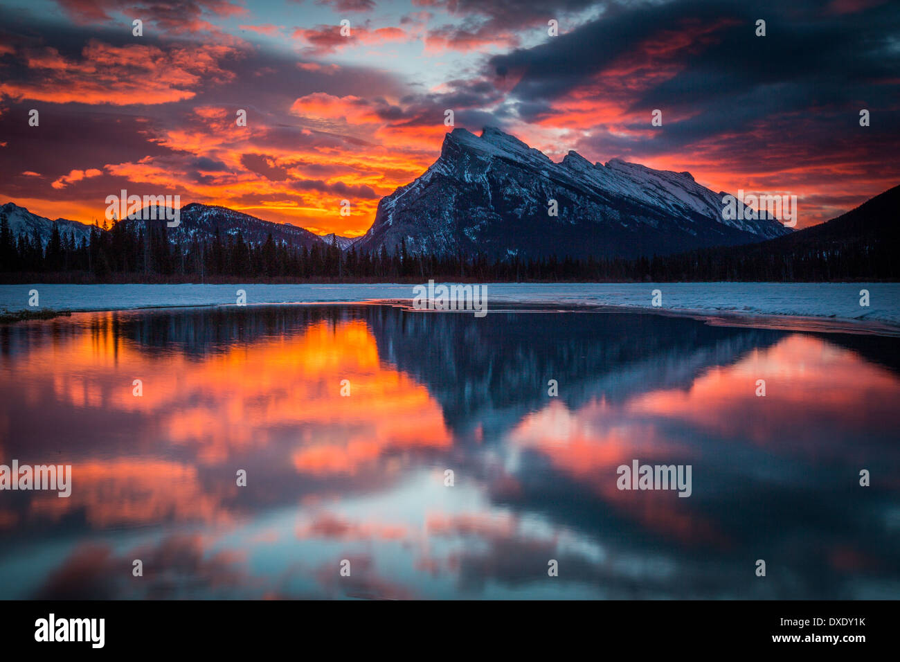 Sunrise nel Parco Nazionale di Banff. Alba si illumina nelle nuvole sopra il Monte Rundle e si riflette nel lago di Vermiglio. Foto Stock