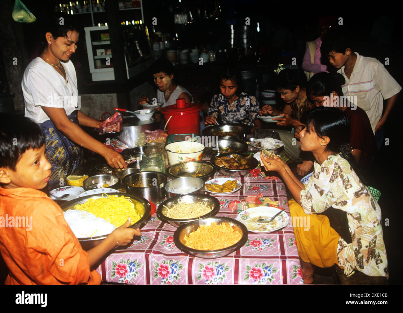 Un giovane ragazzo aiutando sulla sua famiglia la notte di cibo-stallo in Myanmar Foto Stock