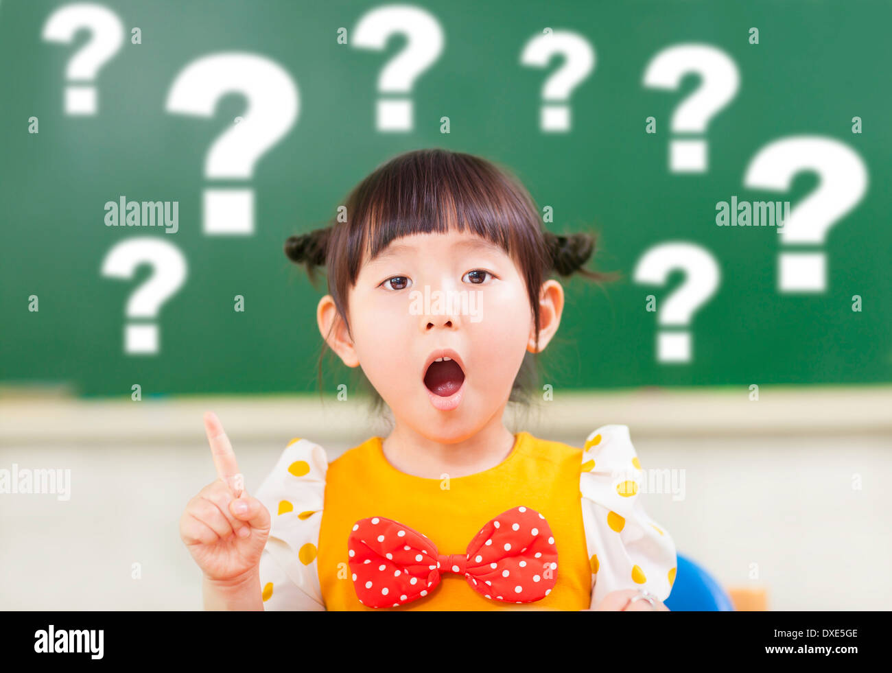 Lo stupore bambina è pieno di domande con Blackboard Foto Stock