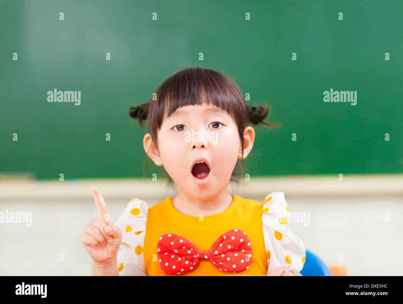 Bambina pensare ad una buona idee con Blackboard Foto Stock