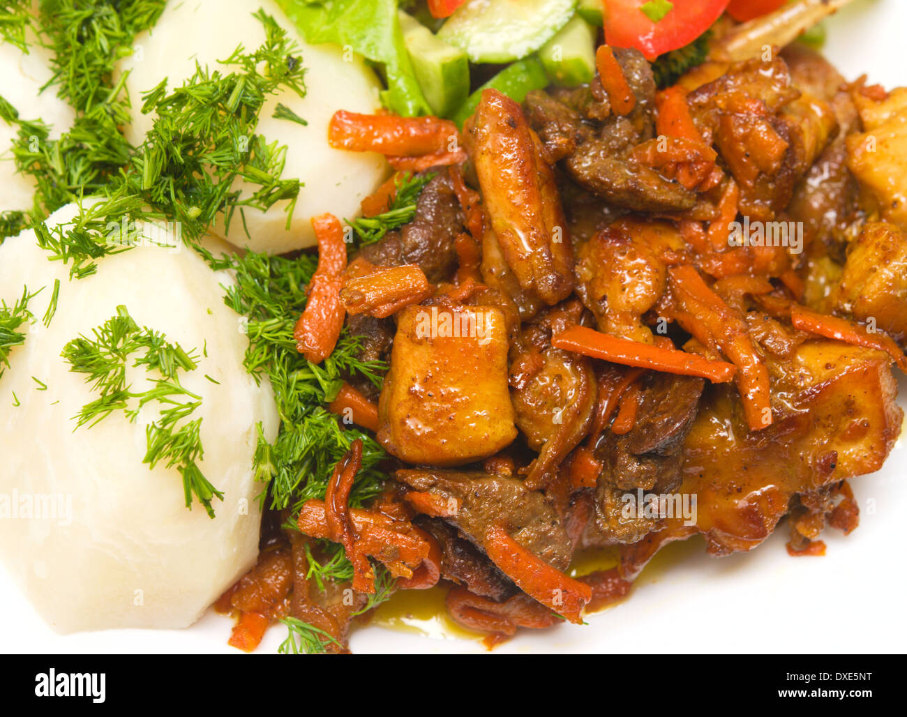 Una chiusura di una carne arrosto con patate su piastra bianca Foto Stock