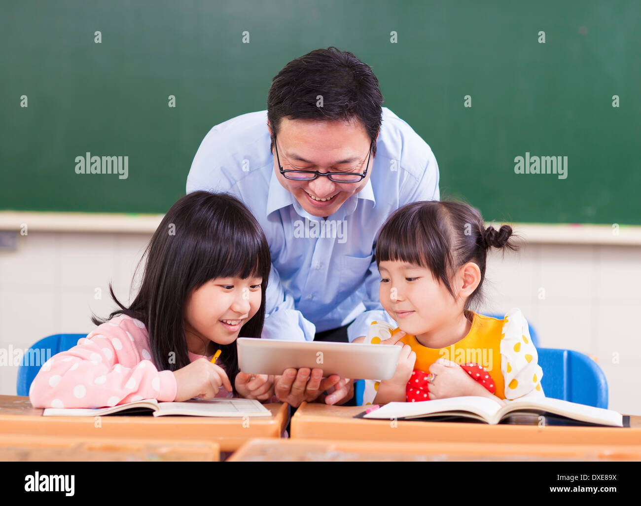 Insegnante per insegnare ai bambini con tavoletta digitale o ipad con l'insegnante Foto Stock