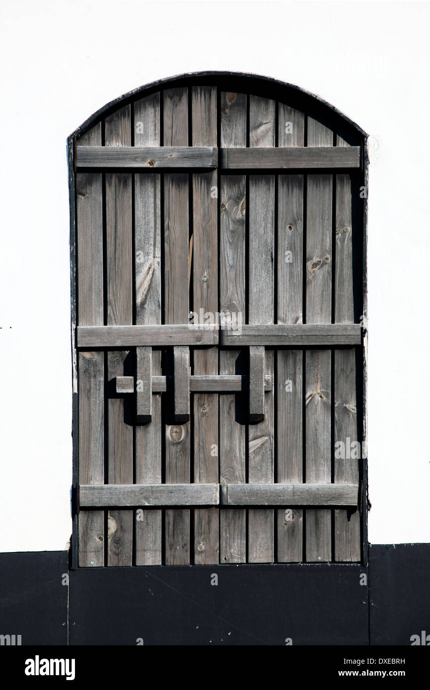 Si tratta di una foto di una finestra nel mezzo di una parete, possiamo vedere il telaio. Si tratta di una finestra di legno o porta. Esso è chiuso Foto Stock