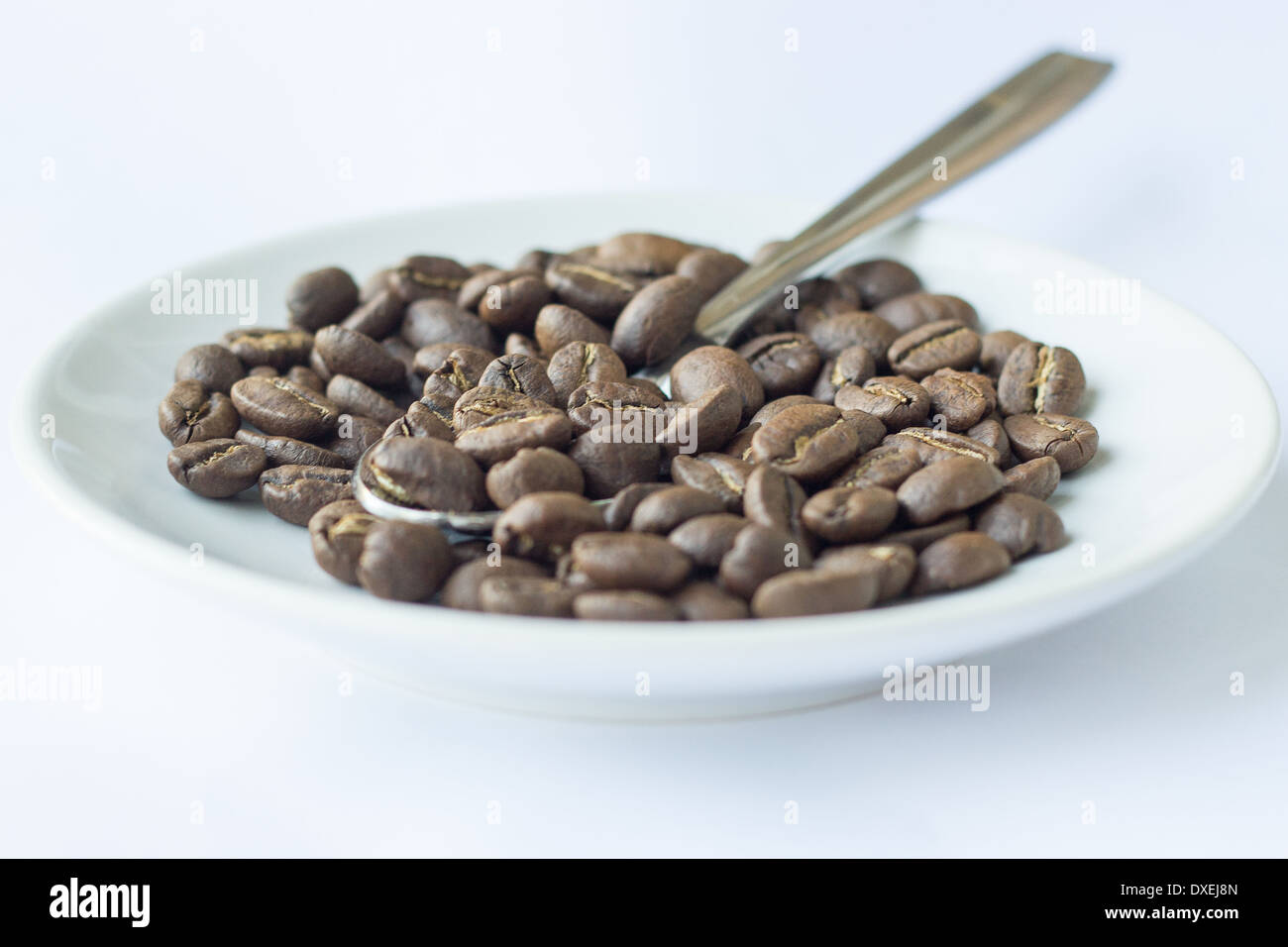 Tutta i chicchi di caffè sulla piastra con il cucchiaio. Foto Stock