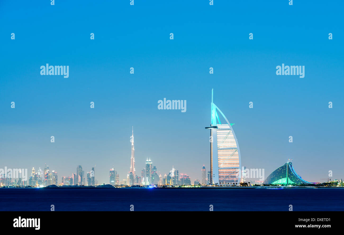 Lo skyline di notte in mare di lusso al Burj al Arab hotel e la città di Dubai con il Burj Khalifa Tower a distanza in United Arab Emira Foto Stock