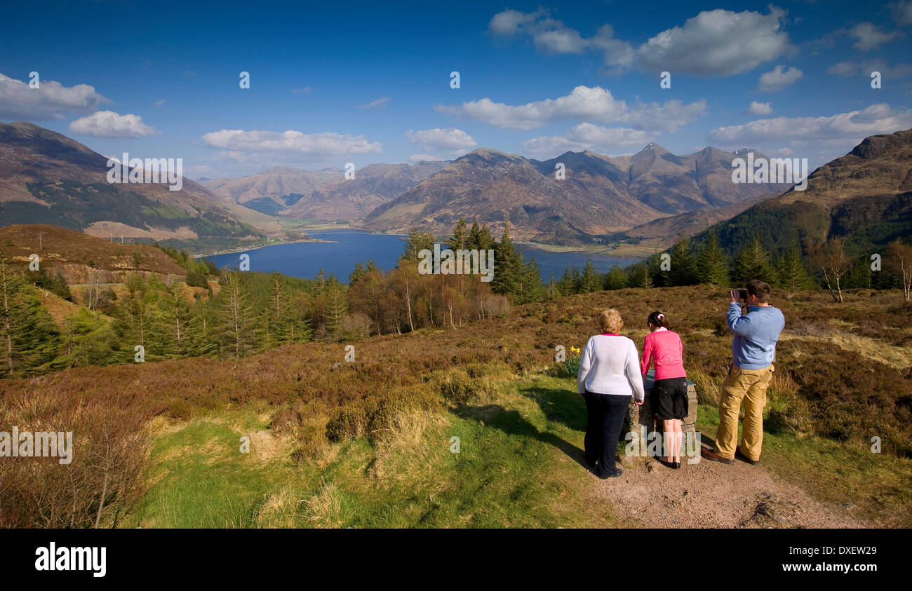 Famiglia godendo la vista mozzafiato di Kintail e Loch Duich dal vertice di Mam Ratagan, West Highlands Foto Stock