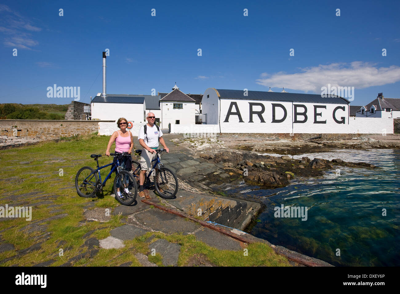 Due visitatori su biciclette presso la distilleria Ardbeg, Islay Foto Stock