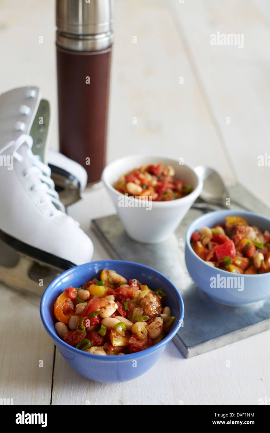 Bocce di Chili Con Thermos e pattini da ghiaccio, Studio Shot Foto Stock