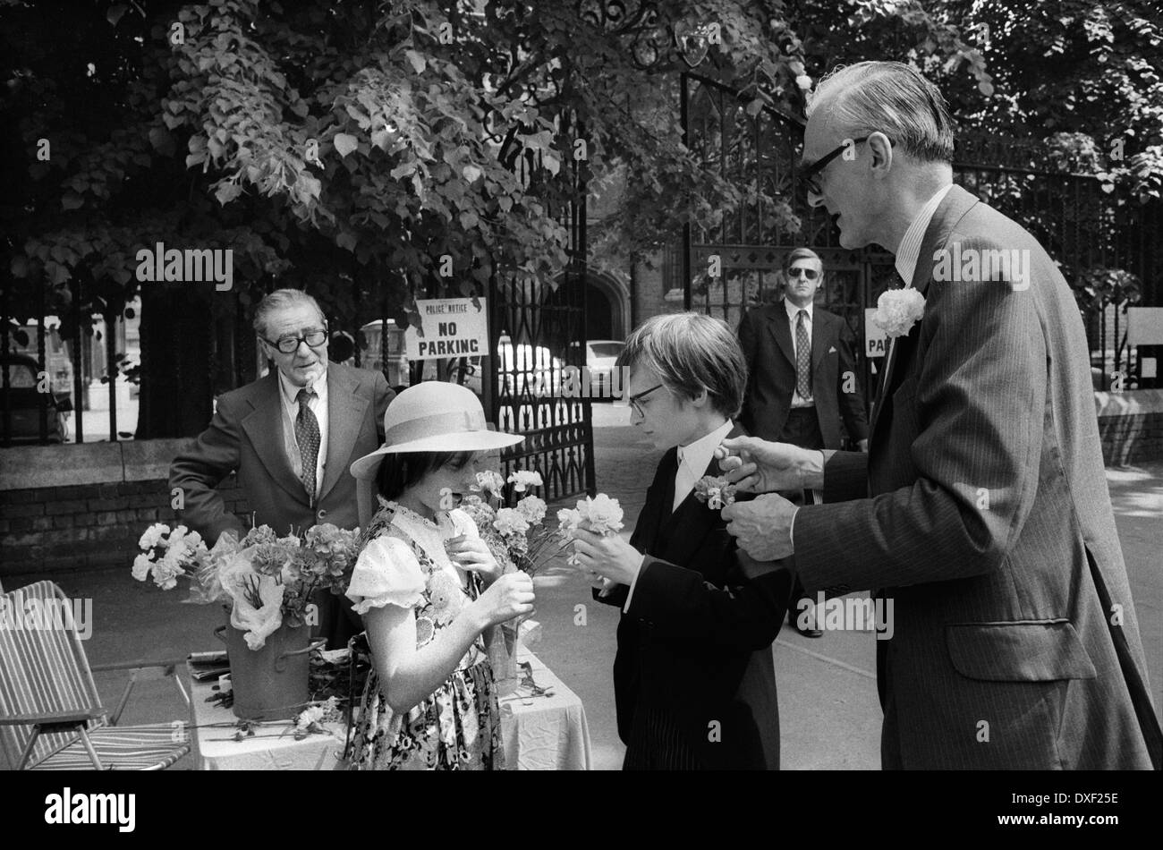 Fiori a bottone, uomo che li vende, che viene venduto fuori Eton College il giorno dei genitori 4 giugno 1978. Padre che compra un fiore per i suoi figli, i ragazzi di Eton. 4 giugno 1970s UK HOMER SYKES. Foto Stock