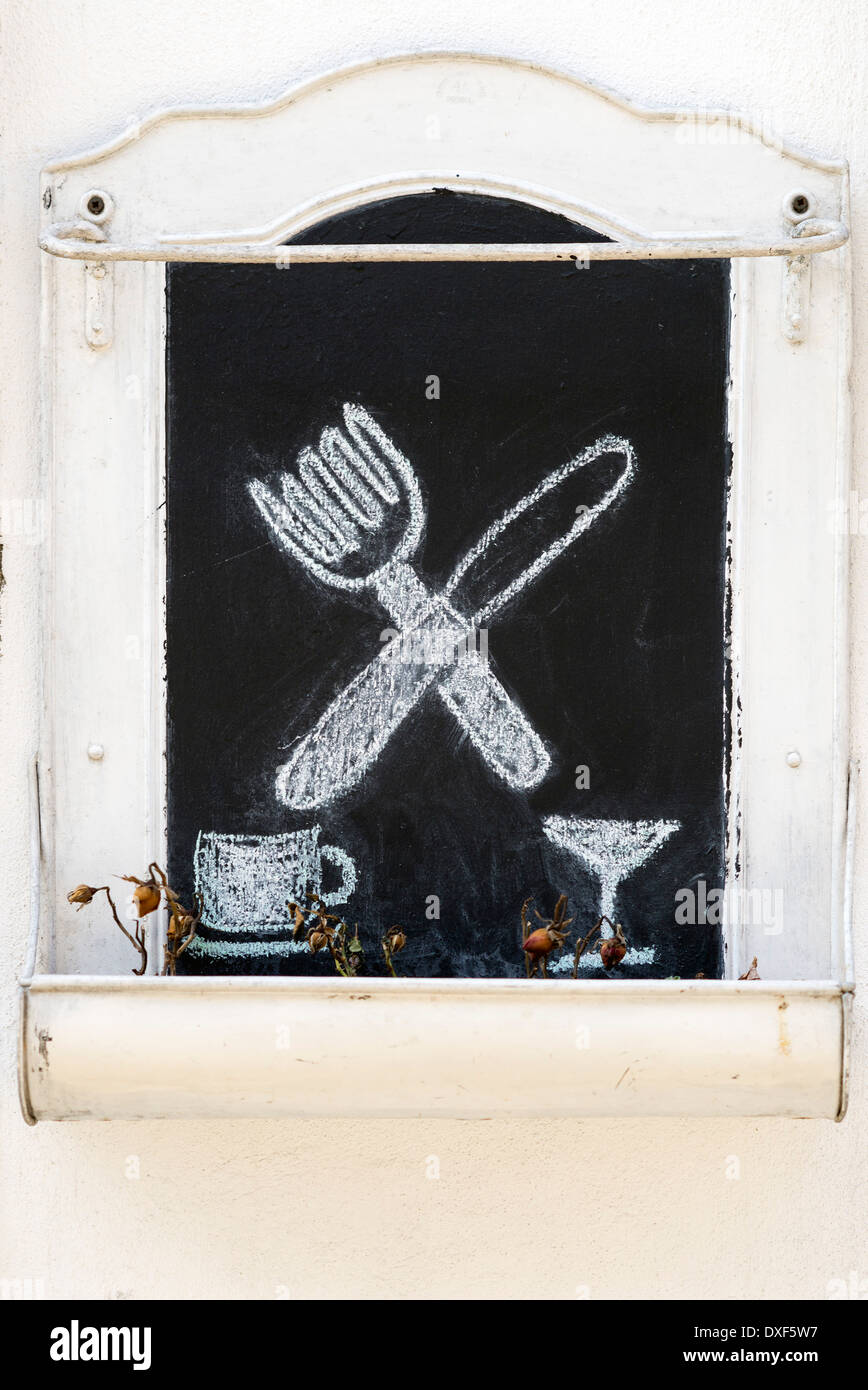 Coltello, forchetta, coppa e mug tracciate con gesso su uno sfondo nero. Foto Stock