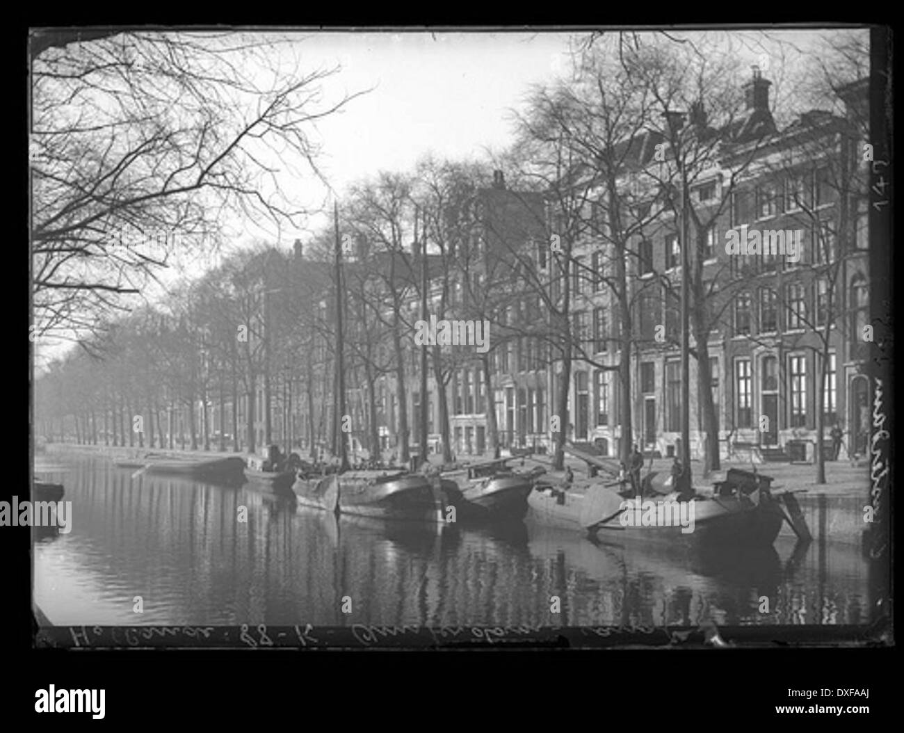 Questa fotografia vintage cattura il canale Hollande di Amsterdam, riflettendo il fascino storico della città. L'immagine mostra l'architettura classica del canale e il suo ruolo nel paesaggio urbano di Amsterdam nei tempi passati. Foto Stock