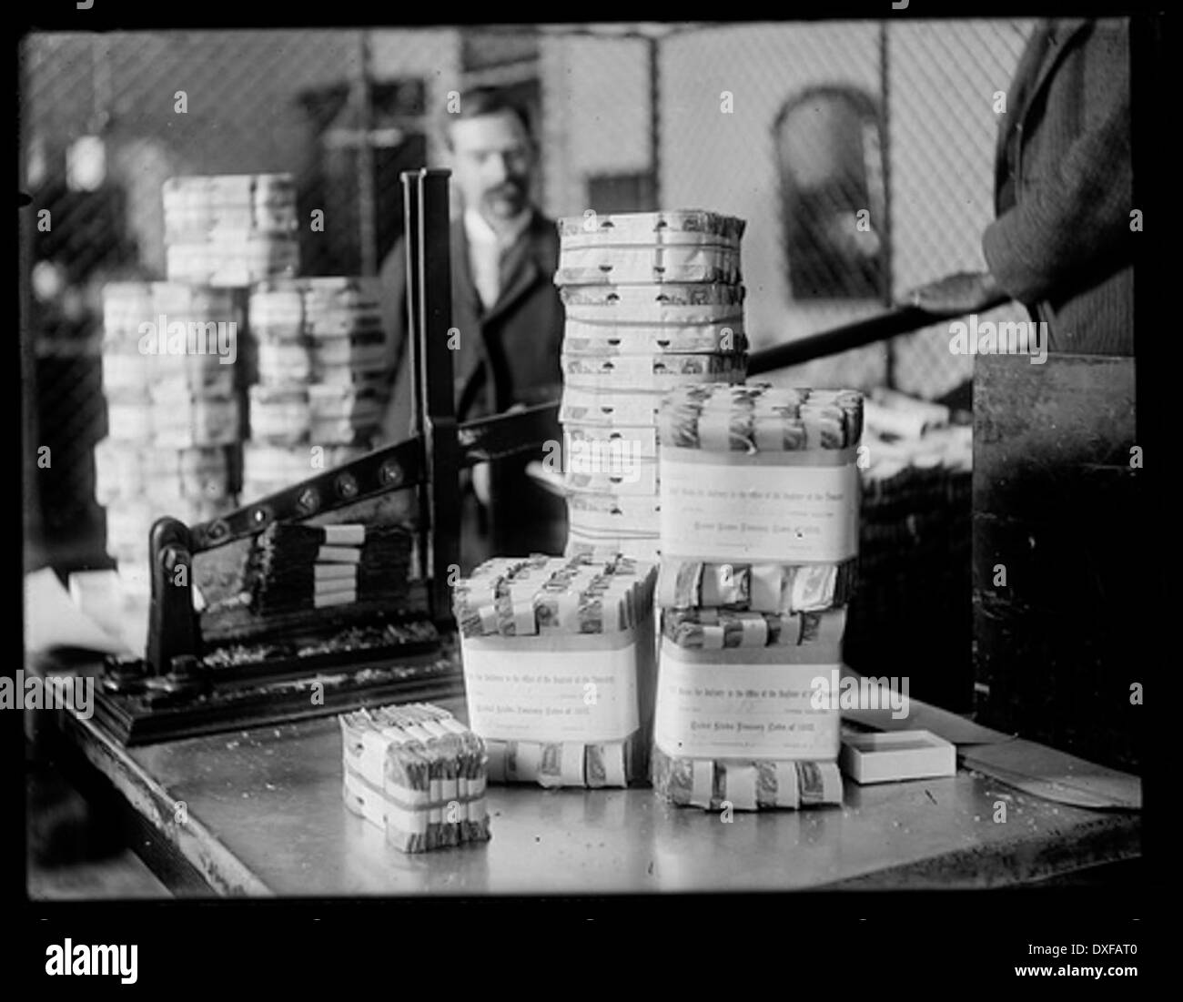 Questa fotografia d'epoca mostra il processo di macerazione del denaro, un metodo utilizzato per la distruzione o il riciclaggio della valuta. L'immagine riflette un aspetto insolito della storia economica, concentrandosi sulla distruzione della moneta fisica. Foto Stock