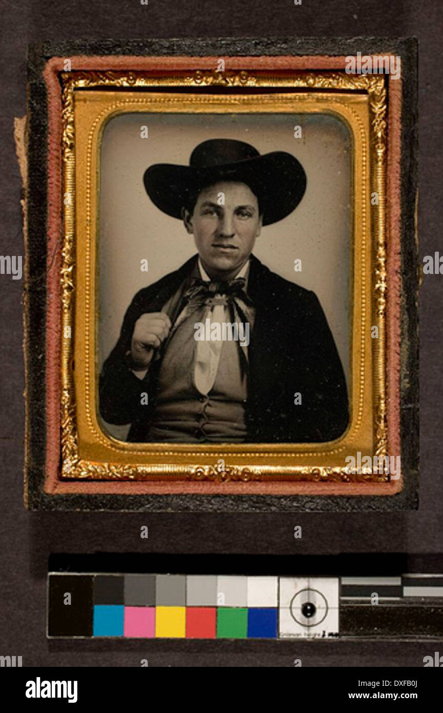 Questa fotografia d'epoca mostra un uomo che indossa un cappello in stile occidentale, tipico della fine del XIX e dell'inizio del XX secolo. La foto rappresenta lo stile culturale e la moda del West americano durante questo periodo. Foto Stock