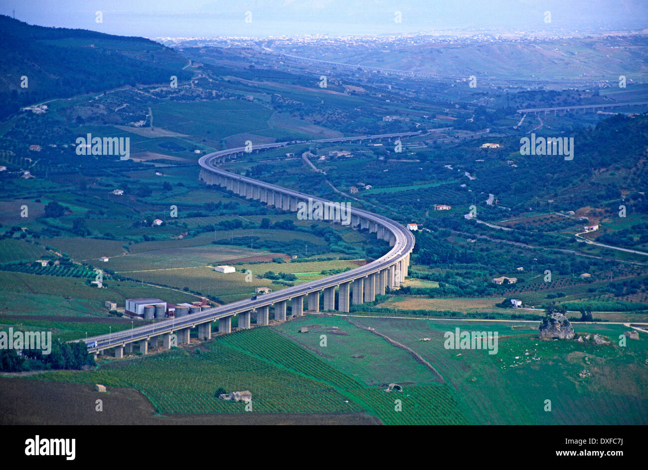 Autostrada sollevata su palafitte attraversando la campagna Sicilia, Italia vista da Segesta verso la costa e Castellammare del Golfo Foto Stock