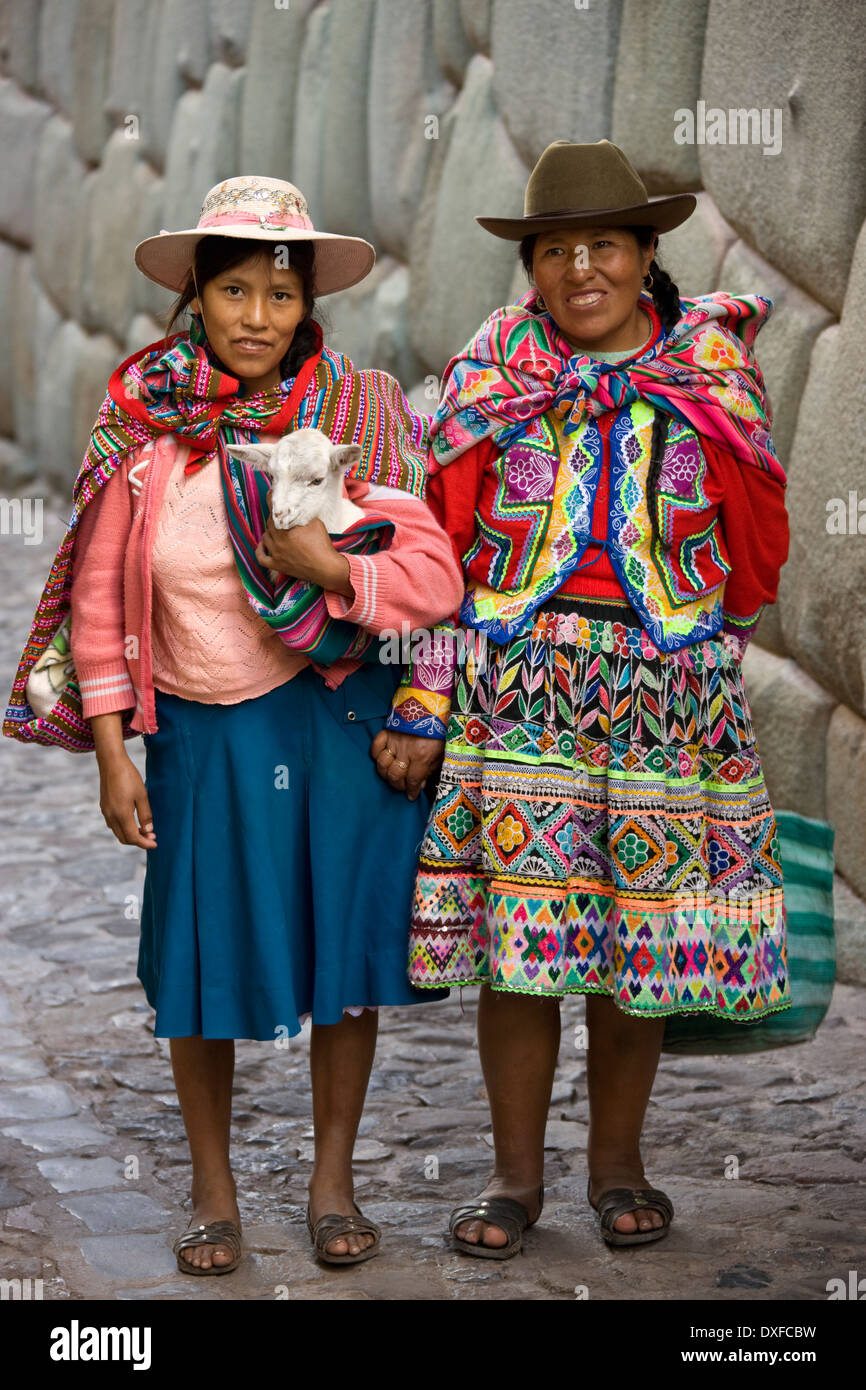 Donne locali a Hatumrumiyoc parete Inca a Cuzco in Perù Foto Stock